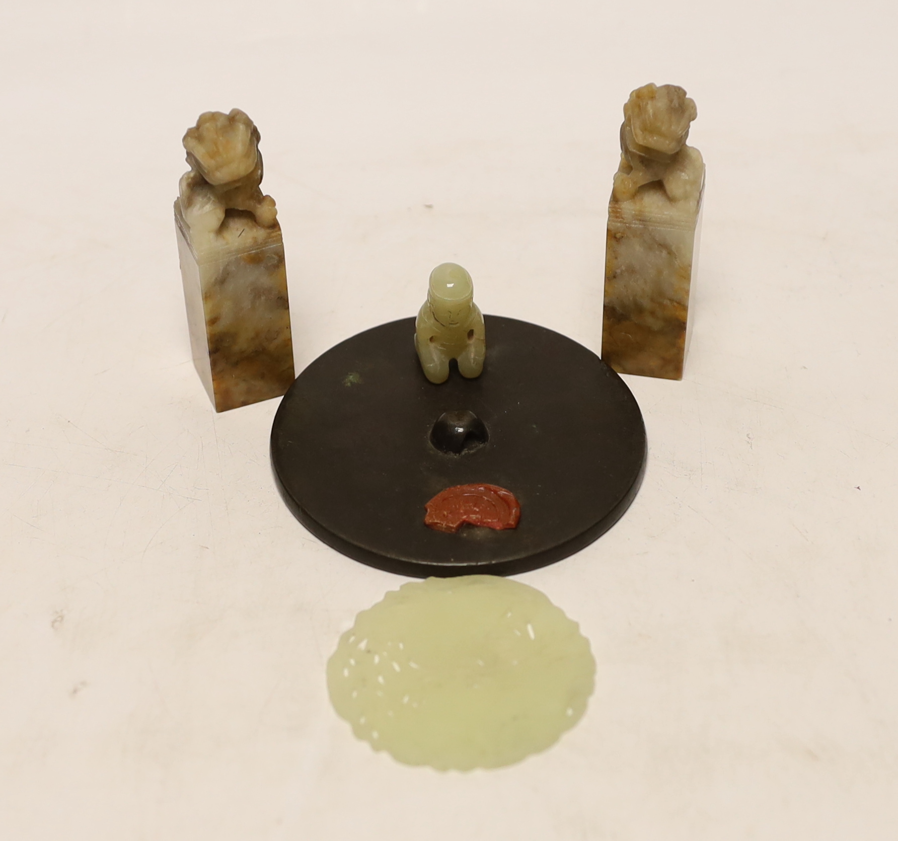 Two Chinese lion dog seals, a carved jade disc, a hard stone disc with partial wax seal and carved figure